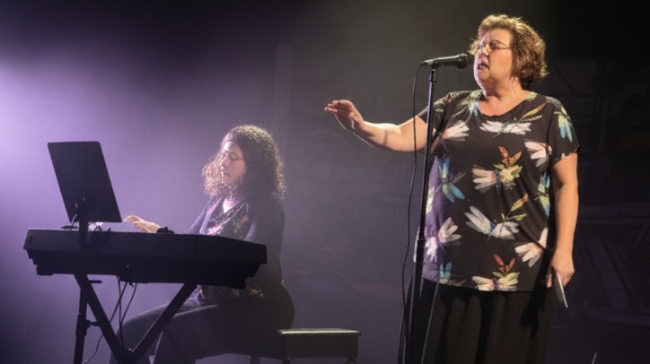 Mary Laymon performing on stage with piano accompaniment - Mary Laymon Voice Studio